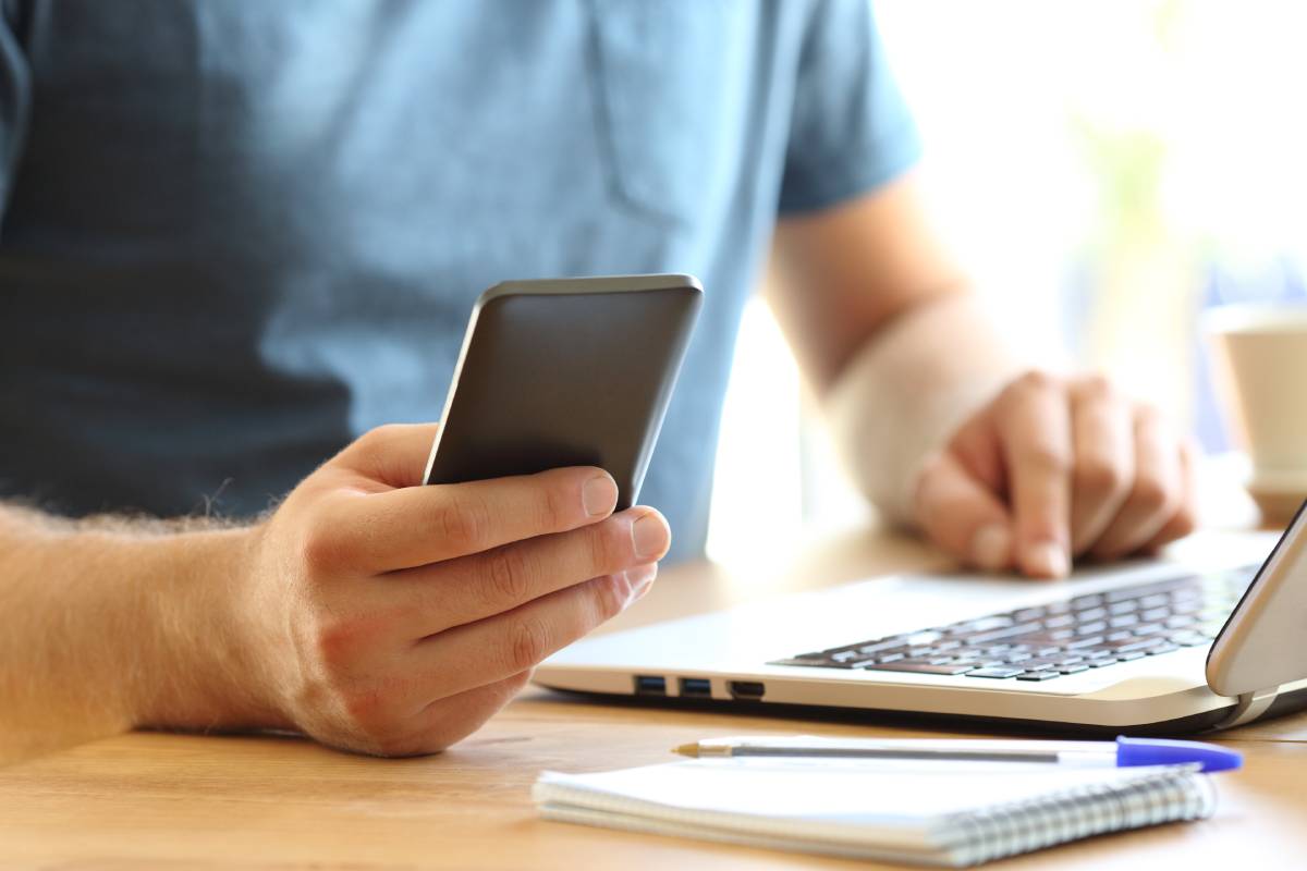 Man working on laptop and phone